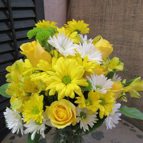 Yellow and white mixed bouquet in a clear glass vase