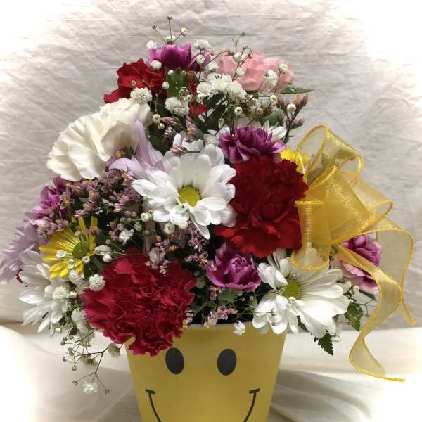 Mixed bouquet in a yellow smiley-face pot with a ribbon bow