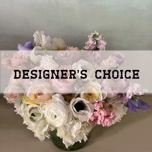 Pastel mixed flower arrangement in a glass vase with designer's choice text overlay