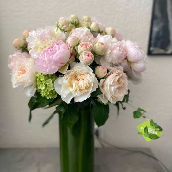 Pink and white bouquet in a tall green vase