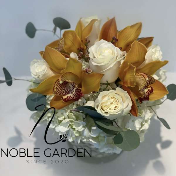 White roses and golden orchids in a low bouquet