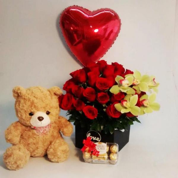 Red roses with yellow orchids, a heart balloon, teddy bear, and chocolates
