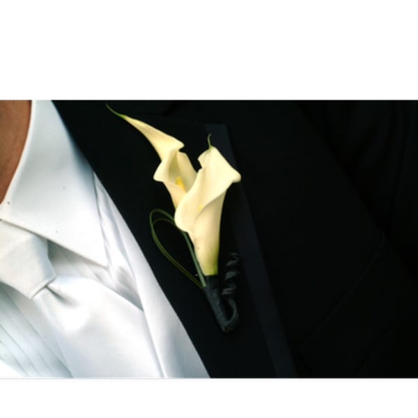 White calla lily boutonniere on a dark suit lapel