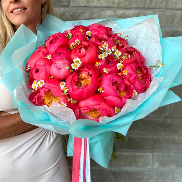 Large bouquet of bright pink peonies with small white daisies
