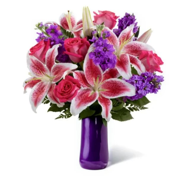 Bouquet of pink roses and lilies in a purple vase
