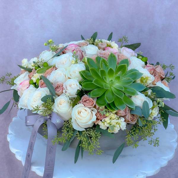 Round bouquet of white and blush roses with a green succulent centerpiece