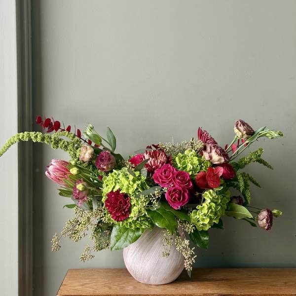 Pink and green floral arrangement in a round vase