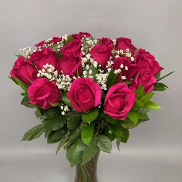 Bouquet of hot pink roses with baby's breath in a clear glass vase