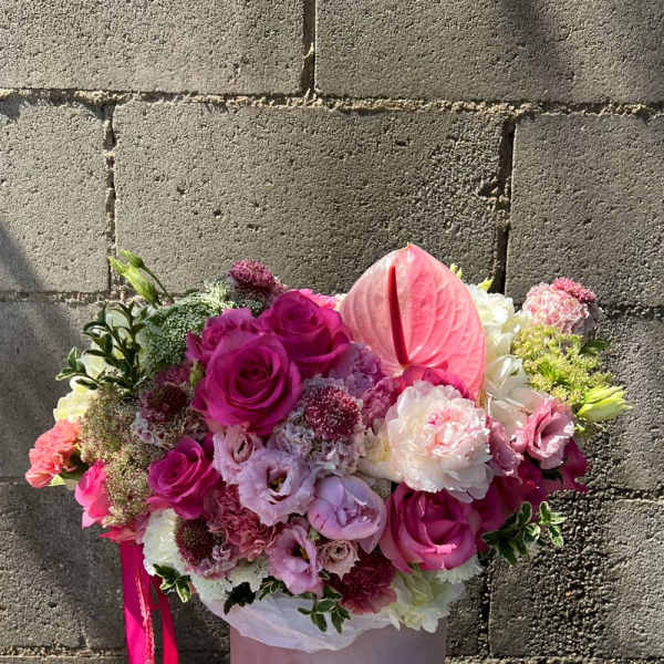 Pink and white bouquet in a pale pink hatbox with a ribbon.