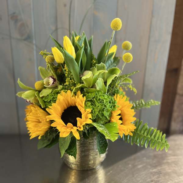 Yellow sunflowers and green flowers in a gold vase
