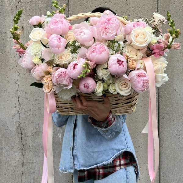 Large basket of pink and white flowers with ribbon streamers