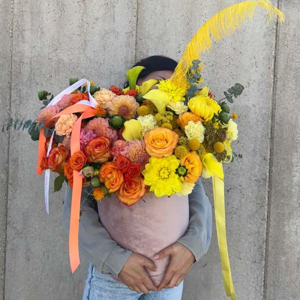 Large bouquet of orange, yellow, and pink flowers with ribbons