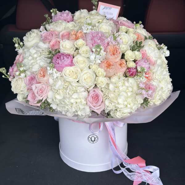 Large bouquet of pink and white roses and hydrangeas in a white hat box