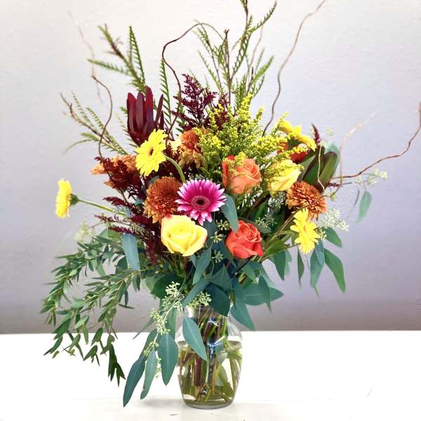 Mixed bouquet of roses and daisies in a glass vase