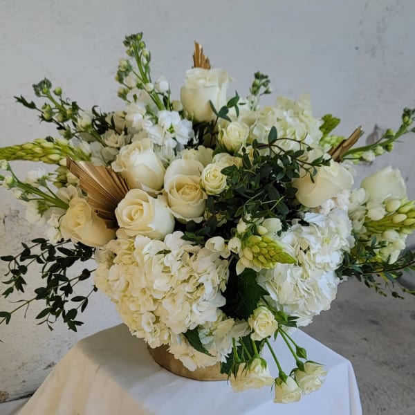 White rose and hydrangea arrangement in a gold vase