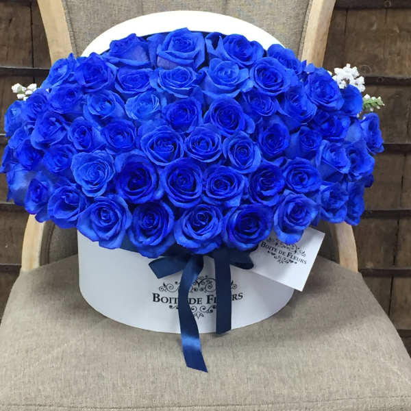 Large bouquet of vivid blue roses in a white hat box with ribbon