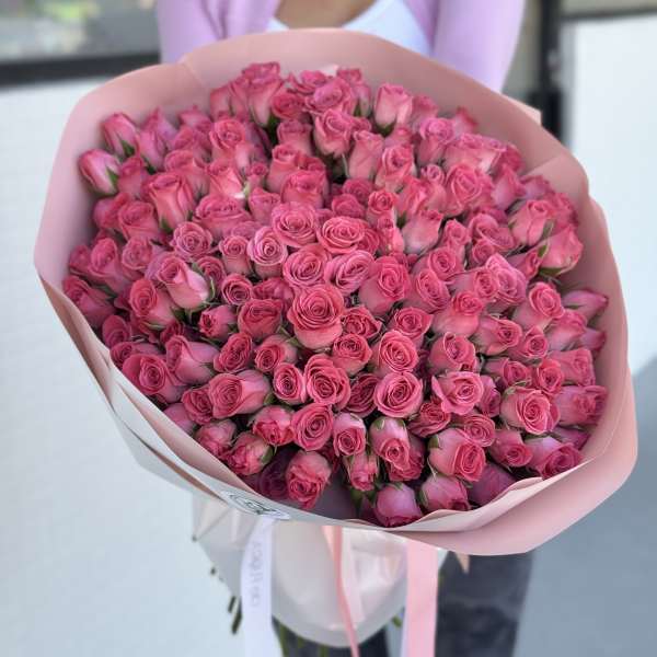 Large bouquet of pink roses wrapped in pale pink paper