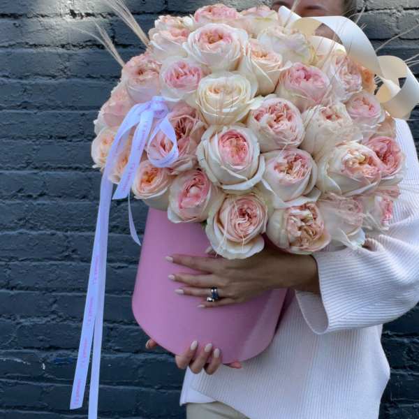 Large bouquet of blush and cream roses in a pink hat box