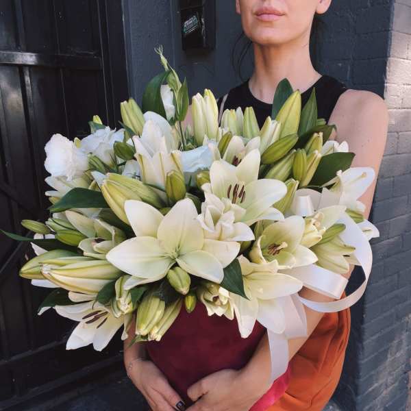 Large bouquet of white lilies held by a person