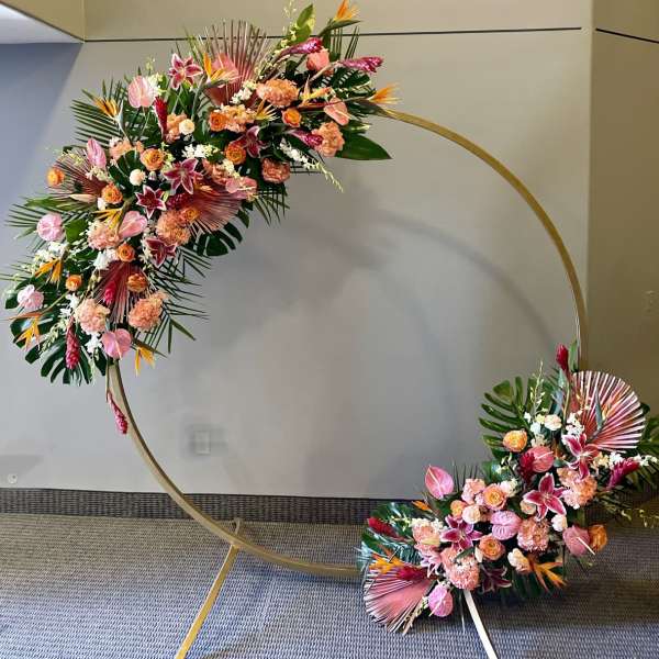 Two floral sprays arranged on a large gold circular frame