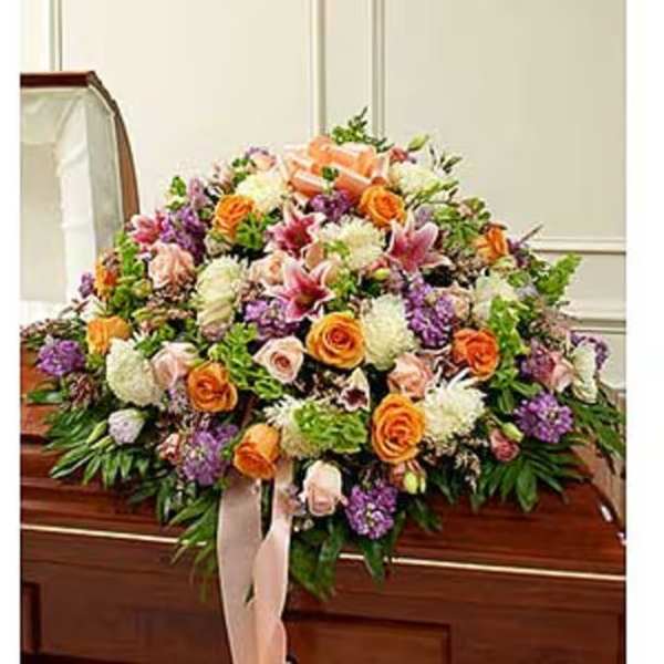 Large floral casket spray with orange, pink, white, and purple blooms