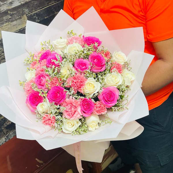 Bouquet of pink and white roses wrapped in white paper