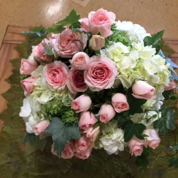 Pink roses and white hydrangeas arranged in a round bouquet