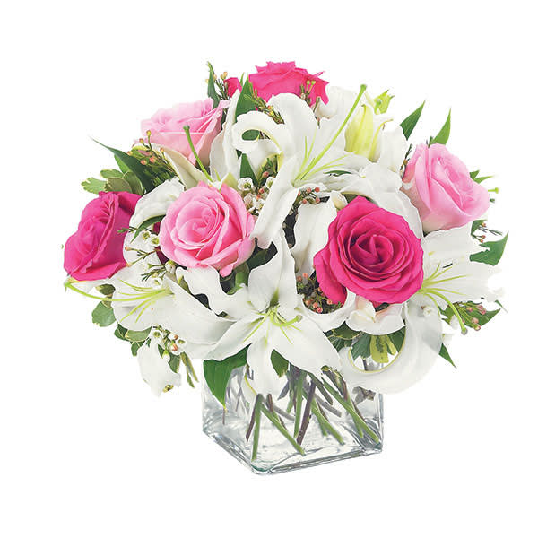 Pink and white rose bouquet in a clear square vase