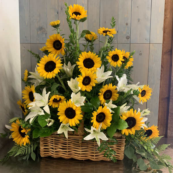 Basket arrangement of sunflowers and white lilies