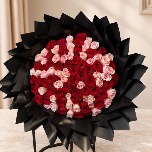 Large bouquet of red and pink roses wrapped in black paper