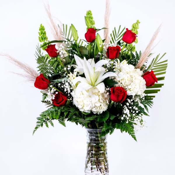 Red roses and white lilies in a clear glass vase