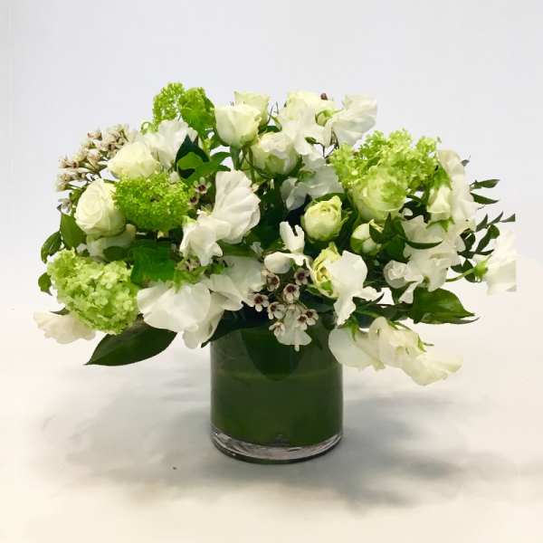 White floral arrangement in a green glass vase