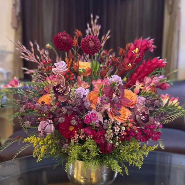 Colorful mixed flower arrangement in a gold vase