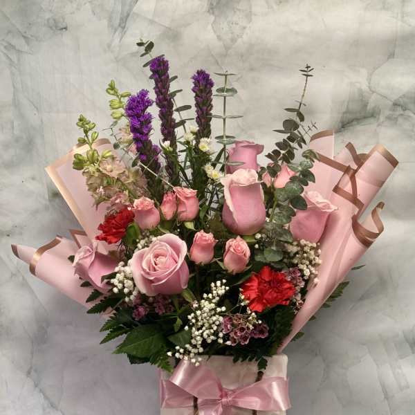 Pink rose bouquet in a gift bag with ribbon