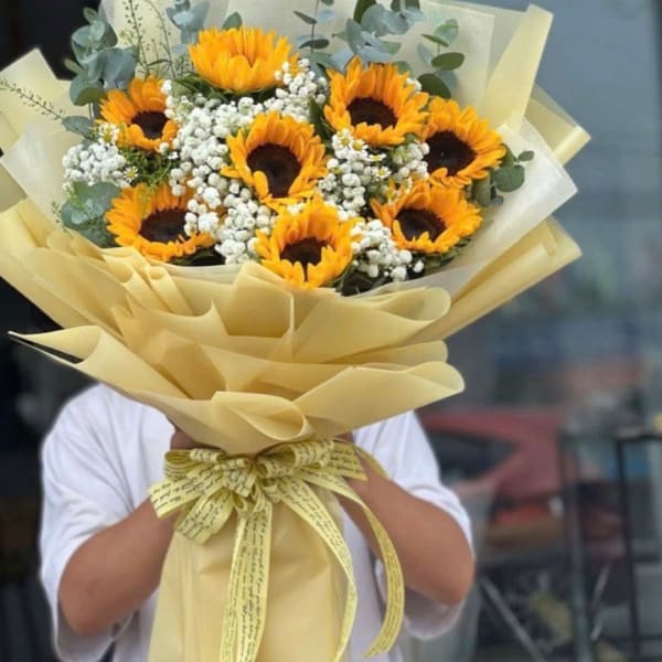 Bouquet of sunflowers and baby's breath wrapped in pale yellow paper