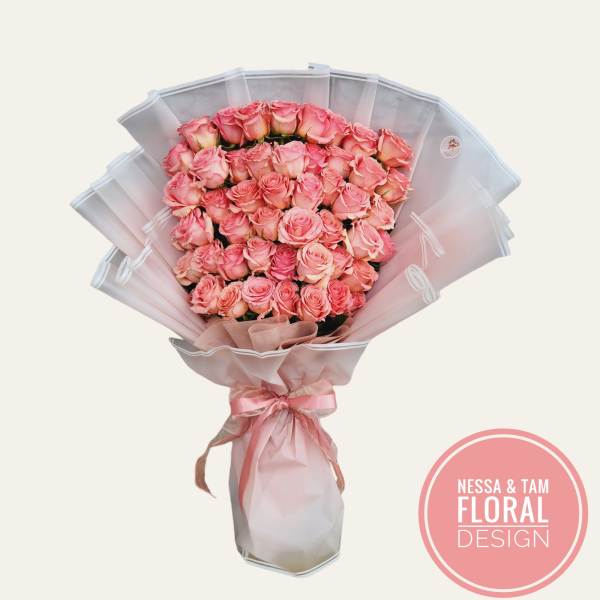 Large bouquet of pink roses wrapped in pale pink paper