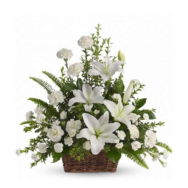 White lilies and carnations arranged in a wicker basket.
