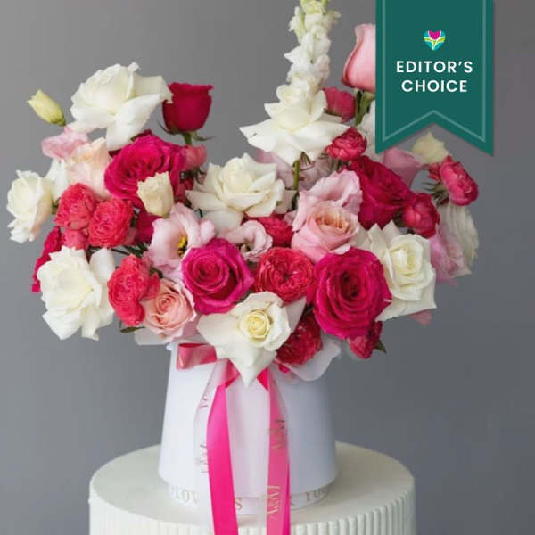 Bouquet of pink, red, and white roses in a white hat box with ribbon