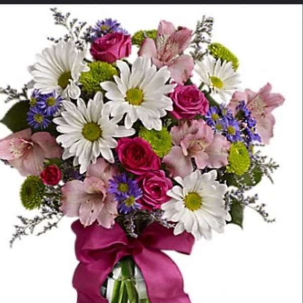 Bouquet of white daisies, pink roses, and pink alstroemeria in a glass vase