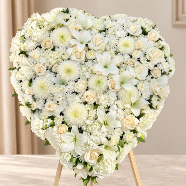 Heart-shaped white floral arrangement on a stand