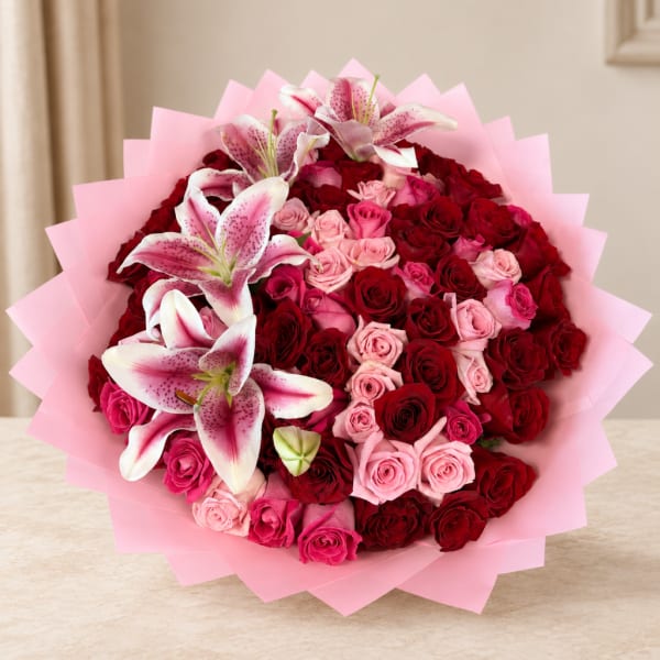 Bouquet of red and pink roses with white-pink lilies in pink wrap