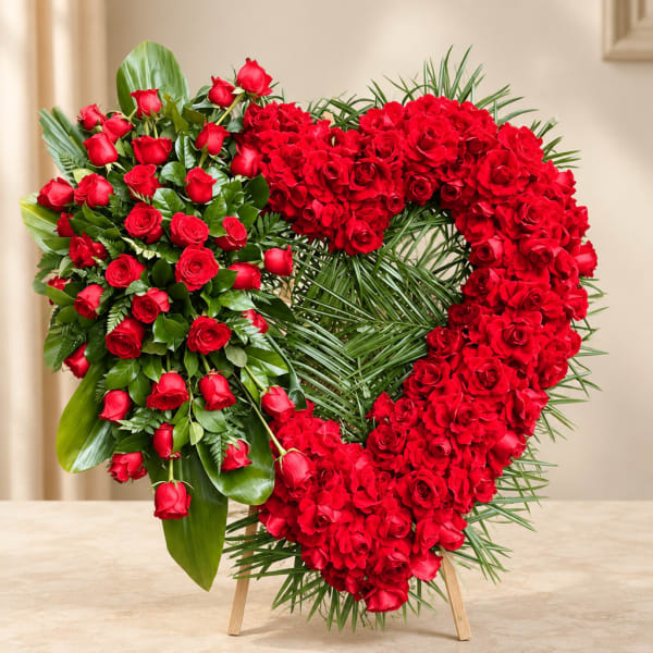 Heart-shaped red rose wreath on a stand