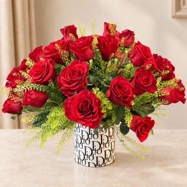 Red roses arranged in a patterned cylindrical vase