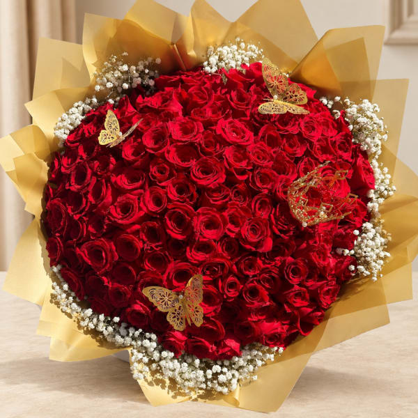 Large bouquet of red roses wrapped in gold paper with butterfly decorations