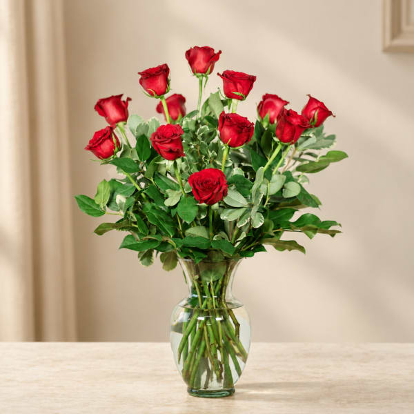 Red roses arranged in a clear glass vase