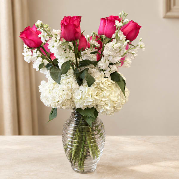 Pink roses and white hydrangeas in a clear glass vase