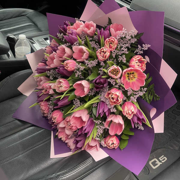 Large bouquet of pink and purple tulips wrapped in pink and purple paper