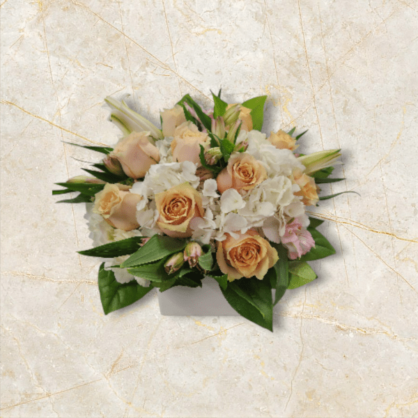 Peach roses and white hydrangeas in a white box arrangement
