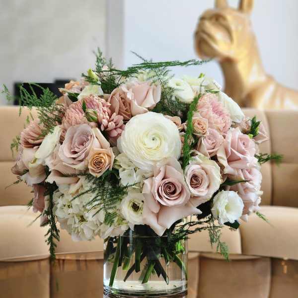Blush and white flower bouquet in a clear glass vase