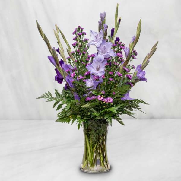 Purple flowers arranged in a clear glass vase